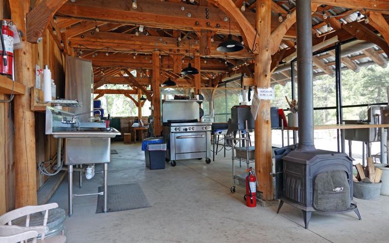 campground cookhouse interior with wood stoves, ovens, sinks, prep tables and more