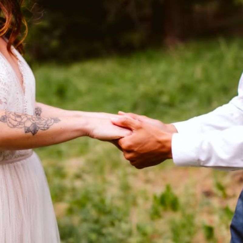 bride and groom holding hands during outdoor wedding ceremony
